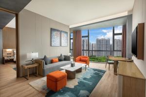 een woonkamer met een bank en een groot raam bij Wyndham Garden Shenzhen Longhua in Shenzhen