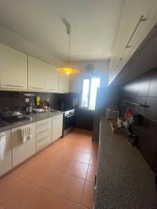 a kitchen with white cabinets and a tile floor at Tini’s Home in Vuno