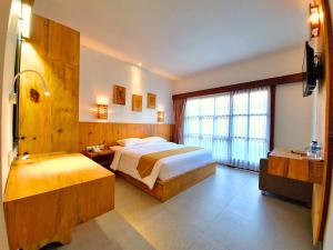 a hotel room with two beds and a large window at Kamandaka Living in Kuta +35 photos