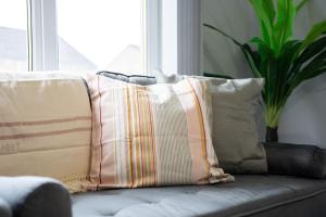 a bunch of pillows sitting on a couch at Linburn Apartment in Glasgow