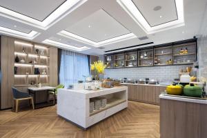 a kitchen with a large island in a room at Morning Hotel, Changsha Yanghu New City Metro Station in Changsha