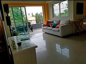ein Wohnzimmer mit einem Sofa und einem Tisch in der Unterkunft Apartamento a 5 minutos Zona Colonial in Santo Domingo
