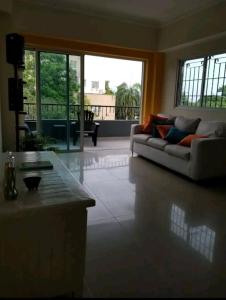 ein Wohnzimmer mit einem Sofa und einem großen Fenster in der Unterkunft Apartamento a 5 minutos Zona Colonial in Santo Domingo