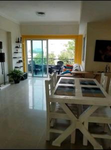 een woonkamer met een houten tafel en stoelen bij Apartamento a 5 minutos Zona Colonial in Santo Domingo