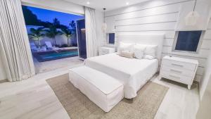 a white bedroom with a white bed and a large window at Unforgettable 3BR Luxury Villa at Porter's Place in Saint James