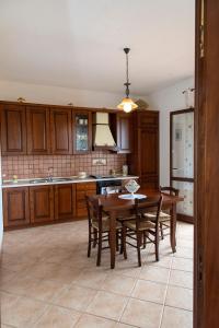 una cocina con armarios de madera, mesa y sillas en Il Rustico di Pino, en Custonaci