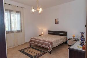 a bedroom with a bed and a chandelier at Il Rustico di Pino in Custonaci