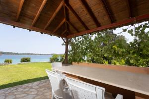 a table and chairs with a view of the water at Villa Egeo - Beachfront Paradise, Starlink, BBQ in Vourvourou