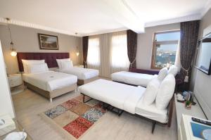 una camera d'albergo con due letti e una televisione di Nea Suites Old City a Istanbul