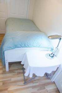 - un lit blanc avec une table blanche et une lampe dans l'établissement Garden Home, à Berkeley