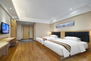 1 dormitorio con 2 camas y TV de pantalla plana en Morninginn, Zhangjiajie Tianmen Mountain, en Zhangjiajie