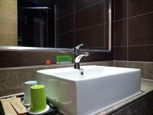 y baño con lavabo blanco y espejo. en Morninginn, Zhangjiajie Tianmen Mountain, en Zhangjiajie