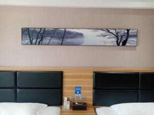 una camera con due letti e una foto sopra la testiera del letto di Morninginn, Zhangjiajie Tianmen Mountain a Zhangjiajie