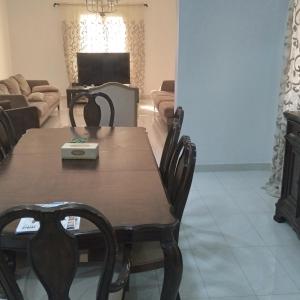 a dining room with a table and a couch at Baran Homestay in Muscat