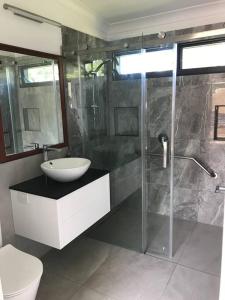 a bathroom with a shower and a sink and a toilet at Coffs Harbour Sanctuary in Coffs Harbour
