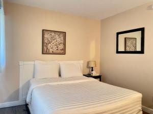 納奈莫的住宿－啟航灣汽車旅館，一间卧室配有一张带白色床单的大床