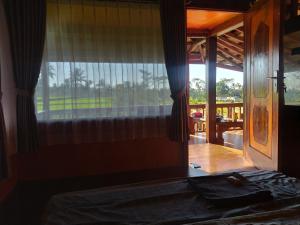 a bedroom with a bed and a window with a view at Jonny's Places in Tetebatu