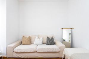 a living room with a white couch with pillows at EDEN RENTALS Cozy City Central Apartment in Santa Cruz de Tenerife
