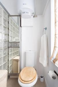 a bathroom with a toilet with a wooden toilet seat at EDEN RENTALS Cozy City Central Apartment in Santa Cruz de Tenerife
