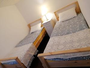 two twin beds in a small room with a lamp at Jono Trobele in Druskininkai