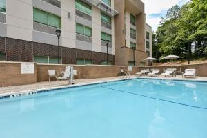 a large swimming pool in front of a building at Holiday Inn Express & Suites Charlotte - Ballantyne, an IHG Hotel in Charlotte