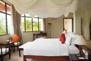 sypialnia z dużym białym łóżkiem i oknami w obiekcie Pax Ana Doc Let Resort & Spa w mieście Ninh Hòa