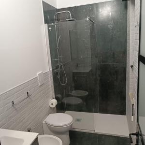 a bathroom with a toilet and a glass shower at LOFT 85 in Baia Verde