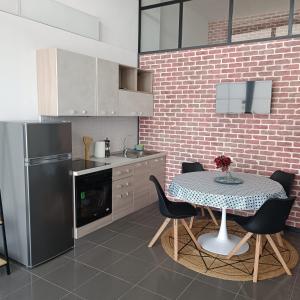 a kitchen with a table with chairs and a refrigerator at LOFT 85 in Baia Verde