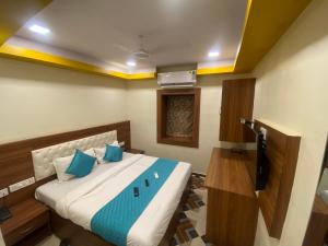 a bedroom with a large bed with blue pillows at Hotel Jodiya - Near CST in Mumbai