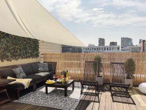 a rooftop patio with a couch and tables and chairs at City center flat w roof top terrace & free parking in Oslo