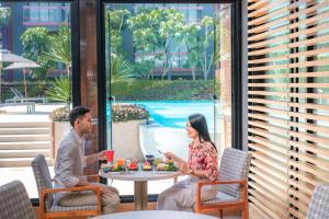 um homem e uma mulher sentados numa mesa num pátio em Holiday Inn Express Phuket Patong Beach Central, an IHG Hotel em Praia de Patong