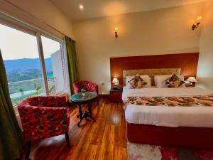 a hotel room with a bed and a table and chairs at Hotel Kempty - A Boutique Hotel, Mussoorie in Mussoorie