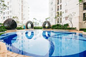 a large blue swimming pool with buildings in the background at RedLiving Apartemen Bassura City - Premium Property in Jakarta