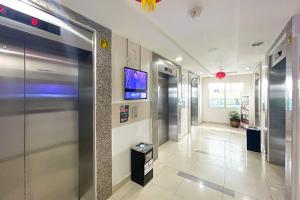 a hallway of a hospital with elevators and a television at RedLiving Apartemen Bassura City - Premium Property in Jakarta