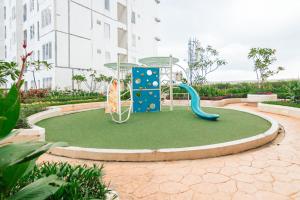 a playground with a slide in a courtyard at RedLiving Apartemen Bassura City - Premium Property in Jakarta