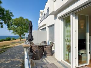 eine Terrasse mit einem Tisch, Stühlen und einem Sonnenschirm in der Unterkunft Ostseeresidenz Sassnitz F548 WG 7 mit Sauna, Terrasse, Meerblick in Sassnitz