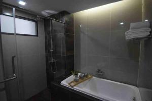 a bathroom with a shower and a tub and a sink at BTS 46 - Near BTS Phrakhanong in Bangkok