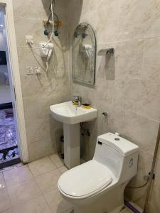 Łazienka z białą toaletą i umywalką w obiekcie شاليهات الفخامة w mieście Ḑubā