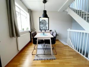 a dining room with a table and chairs at City center flat w roof top terrace & free parking in Oslo