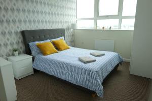 1 dormitorio con 1 cama con almohadas amarillas en 1 bedroom city centre apartment en Birmingham