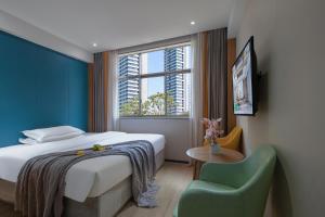 Un dormitorio con una cama y una silla y una ventana. en Morninginn, Malan Mountain Metro, en Changsha