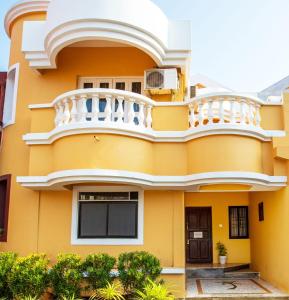 een geel huis met een balkon bij 'Golden Coral' 2bhk Benaulim Beach villa Goa in Madgaon