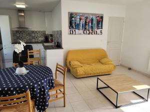 a living room with a table and a yellow couch at Maison sur ile d'Oléron in Saint-Pierre-dʼOléron