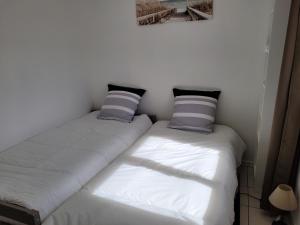 two beds sitting next to each other in a room at Maison sur ile d'Oléron in Saint-Pierre-dʼOléron