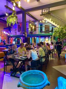 a group of people sitting at tables in a restaurant at Moonlight Villa in Phnom Penh