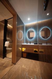 uma casa de banho com um lavatório e 2 espelhos em Luyuan Hotel, Shunde Plaza em Ningyuan