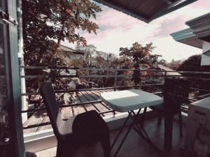 a patio with a table and chairs on a balcony at The Two-Bedroom Balcony House Tagaytay in Tagaytay