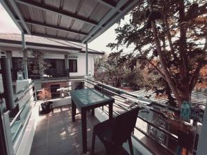 a patio with a table and chairs on a balcony at The Two-Bedroom Balcony House Tagaytay in Tagaytay