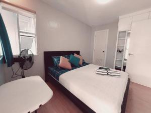 a bedroom with a bed and a chair and a window at The Two-Bedroom Balcony House Tagaytay in Tagaytay