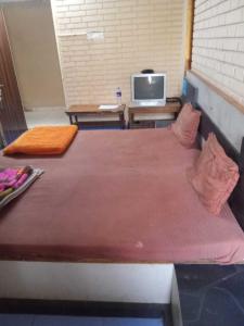 a bedroom with two beds and a tv on a table at SPOT ON Hotel Ellora in Raipur